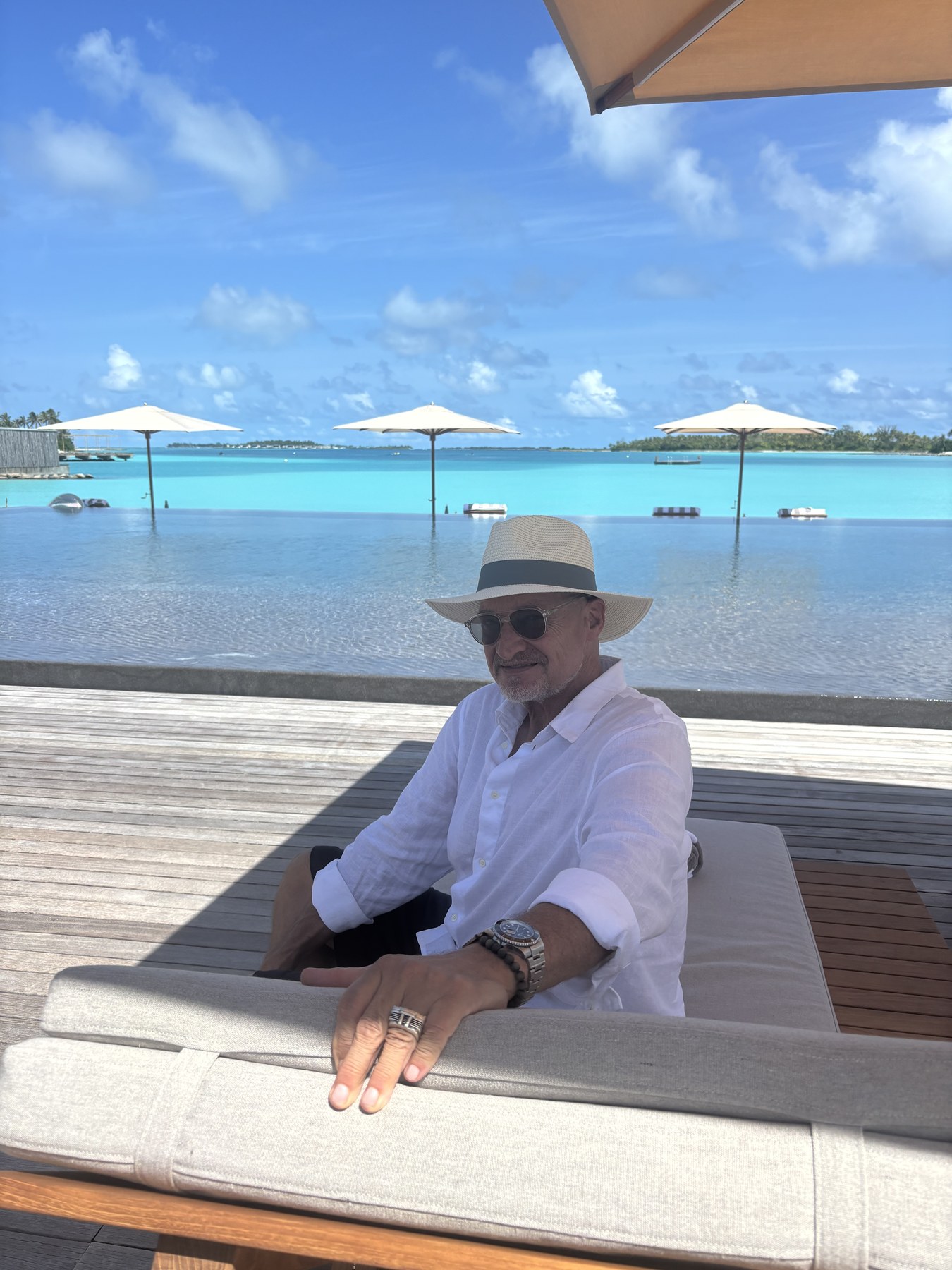 Michael in a straw hat beside a lagoon, looking back at the camera.