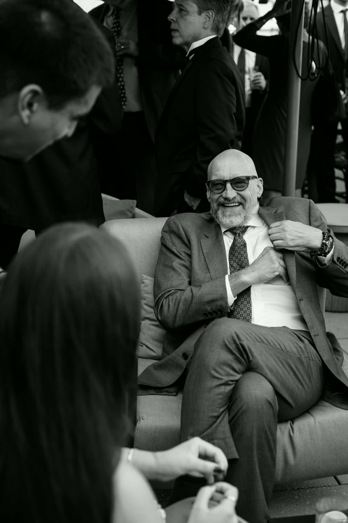Michael, laughing, seated among friends.